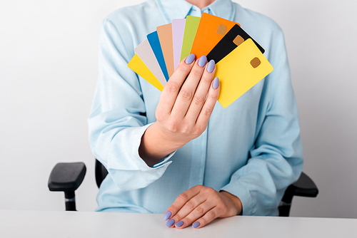 cropped view of woman holding multicolored credit card templates isolated on white