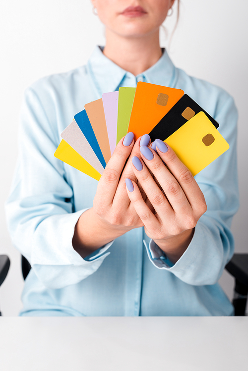 cropped view of woman holding colorful credit card templates isolated on white
