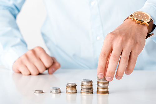 cropped view of man touching stack of coins isolated on white