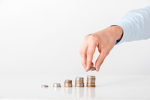 cropped view of man taking coin from stack on white