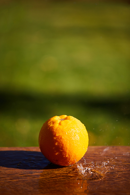 selective focus of whole and wet orange on wooden surface