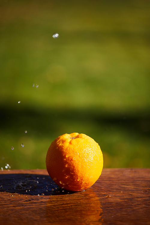 selective focus of whole and wet orange on wooden surface