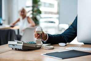 cropped view of businessman holding retro phone in office