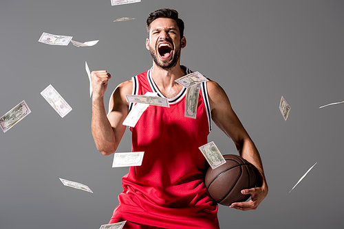 yelling basketball player with ball Isolated On grey with falling money