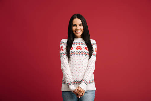 smiling girl posing in winter sweater isolated on red
