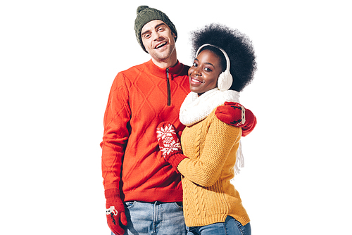 multiethnic couple hugging in sweaters and gloves, isolated on white