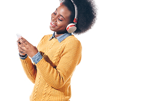 cheerful african american girl using smartphone with headphones, isolated on white