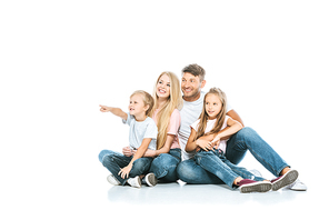 happy boy pointing with finger near sister and parents on white