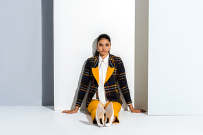 young and stylish woman sitting on grey and white