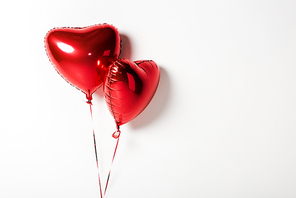 shiny and red heart shaped balloons on white