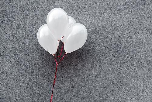 white and decorative balloons on grey with copy space
