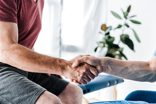 cropped view of doctor shaking hands with man