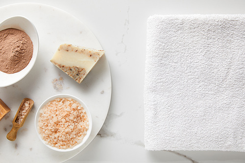 top view of clay powder, 씨솔트 and soap on marble table near white cotton towel