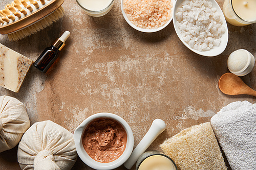 top view of natural cosmetics and beauty supplies on textured weathered beige surface