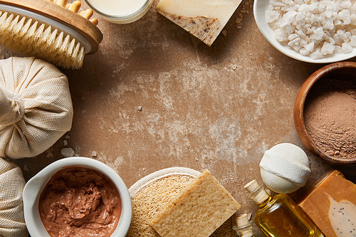 top view of natural cosmetic ingredients on textured weathered beige background with copy space