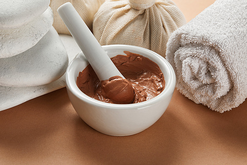 close up view of clay, stones and white cotton towel on beige surface