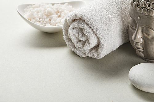 씨솔트 in bowl, cotton towel, stone and buddha figurine on white background