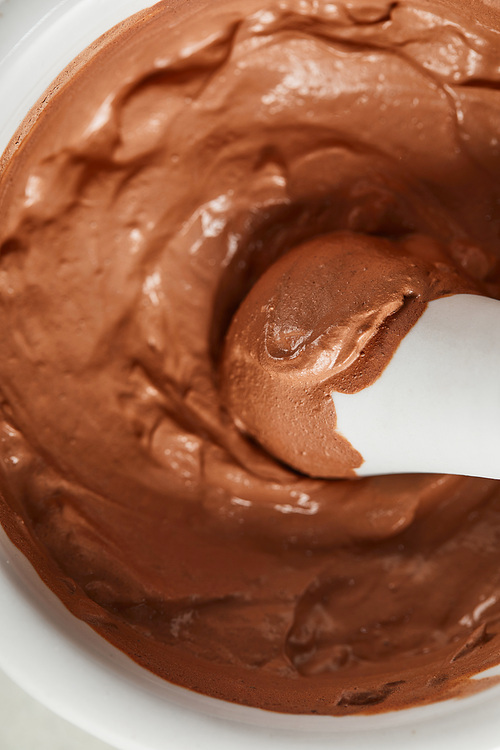 close up view of brown viscous clay in white bowl