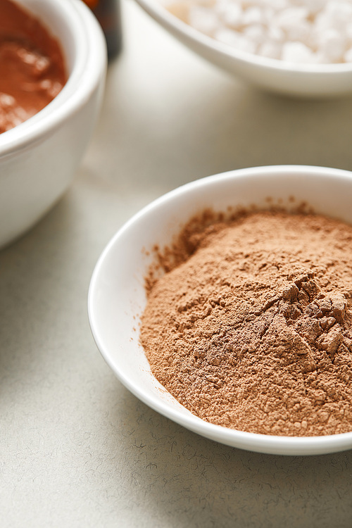 close up view of brown clay powder in white bowl