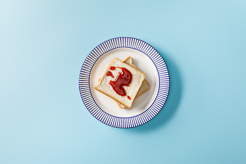 top view of toasts with jam on plate on blue background