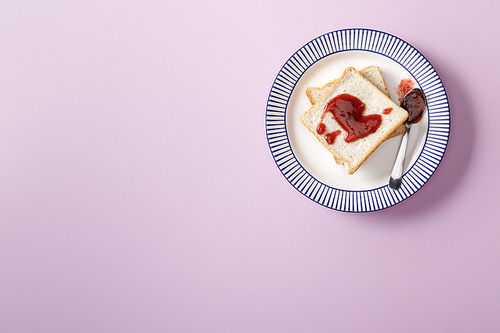 top view of toasts with jam on violet background