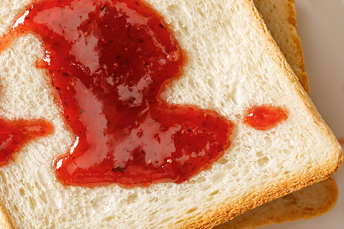 close up view of toasts with jam on white plate