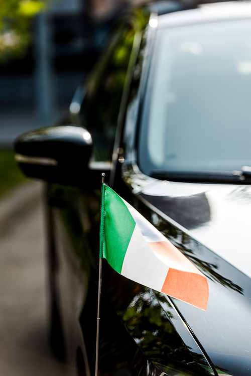 selective focus of irish flag on  modern black car