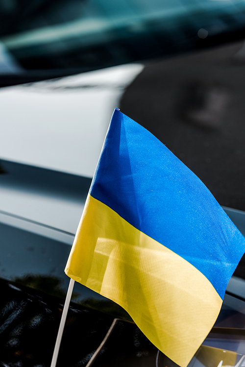 close up on ukrainian flag near black modern car