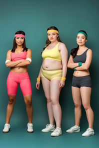 Multiethnic sportswomen with crossed arms  on green