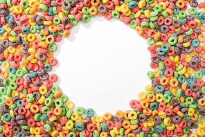 top view of bright multicolored breakfast cereal arranged in round frame on white background