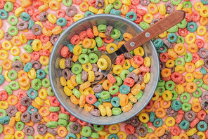 top view of bright colorful breakfast cereal in bowl with spoon