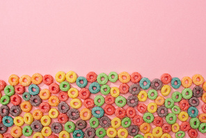 top view of bright colorful breakfast cereal on pink background