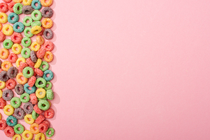 top view of bright colorful breakfast cereal on pink background