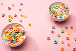 bright colorful breakfast cereal with milk in bowls on pink background