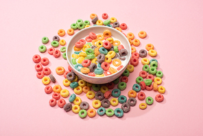 bright colorful breakfast cereal with milk in bowl and around on pink background