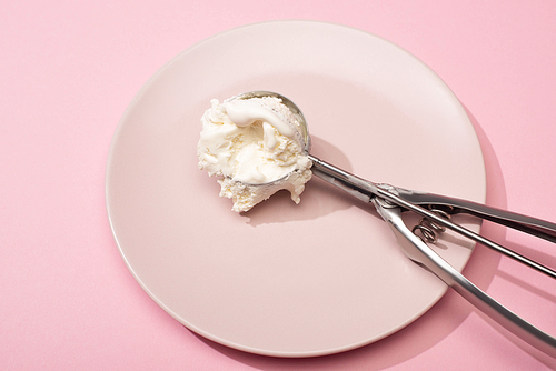 High angle view of scoop with ice cream on plate on pink