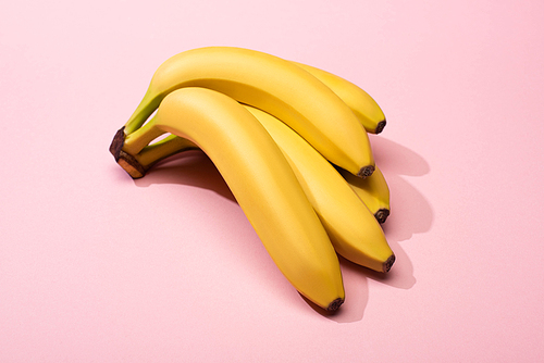 High angle view of ripe yellow bananas on pink background
