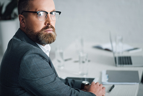 handsome businessman in formal wear and glasses  in office