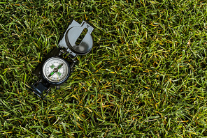 top view of retro compass on green grass