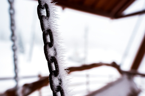 close up view of frozen chain covered with ice of swing