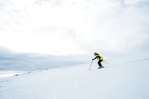 sportsman in helmet skiing in wintertime