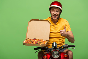 smiling delivery man in yellow uniform on scooter with pizza showing thumb up isolated on green