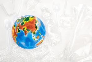 Top view of globe on plastic garbage on white background, global warming concept