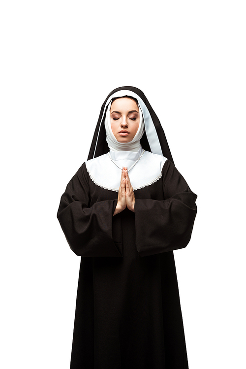 nun praying with closed eyes and hands together isolated on white