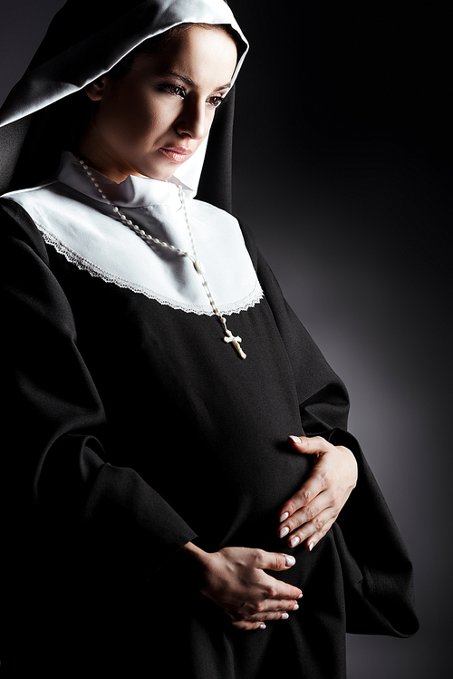 crying pregnant nun touching tummy on grey