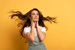 attractive smiling girl in with long hair on yellow