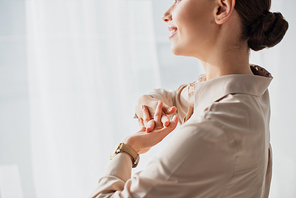 cropped view of smiling businesswoman stretching hands in office
