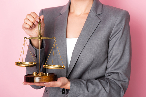 cropped view of businesswoman holding scales on pink, gender equality concept