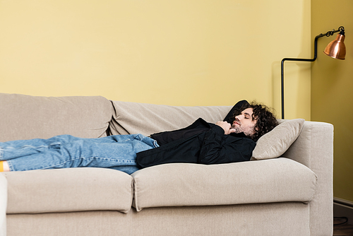 Side view of man lying on couch in living room