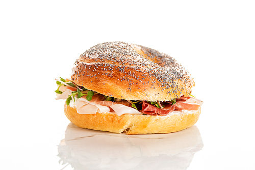 fresh delicious bagel with prosciutto on white background